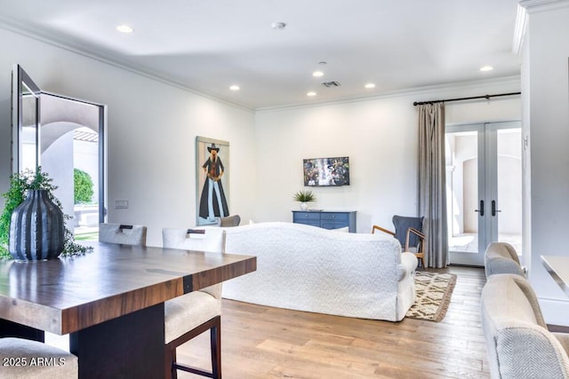 dining room with visible vents, light wood-type flooring, ornamental molding, and recessed lighting