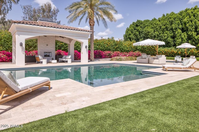 pool with a ceiling fan, a gazebo, a patio area, and an outdoor living space with a fireplace