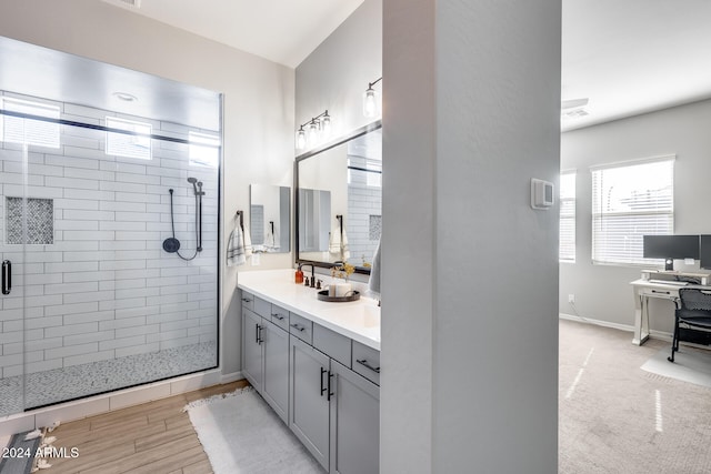 bathroom with hardwood / wood-style flooring, vanity, and walk in shower