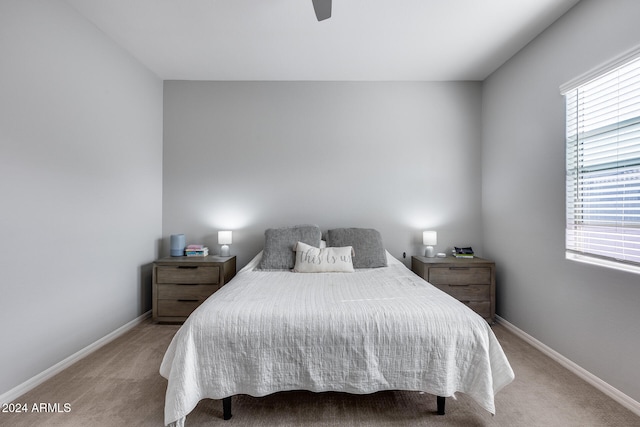 bedroom featuring light carpet, multiple windows, and ceiling fan