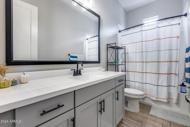 bathroom with toilet, vanity, and hardwood / wood-style flooring