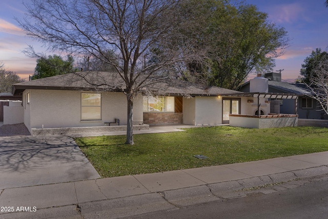 view of front of home with a lawn, a patio area, and stucco siding