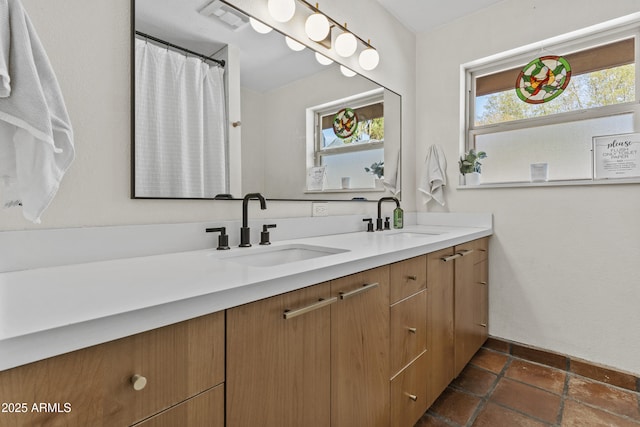 full bath with visible vents, a sink, and double vanity