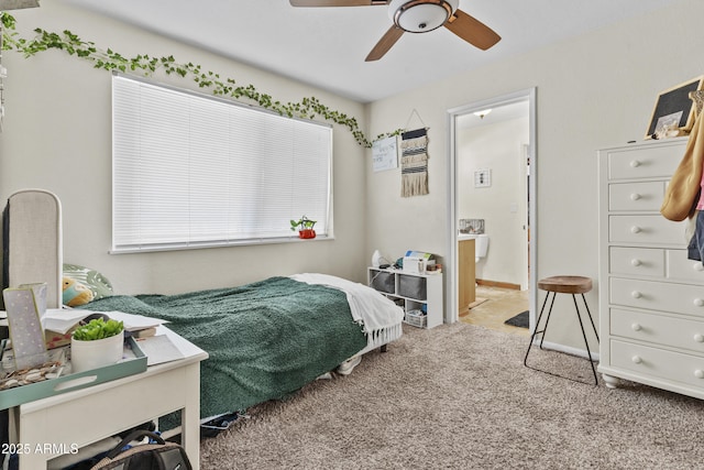 bedroom with ensuite bathroom, ceiling fan, carpet flooring, and baseboards