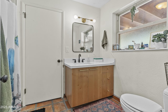 full bath featuring vanity and toilet