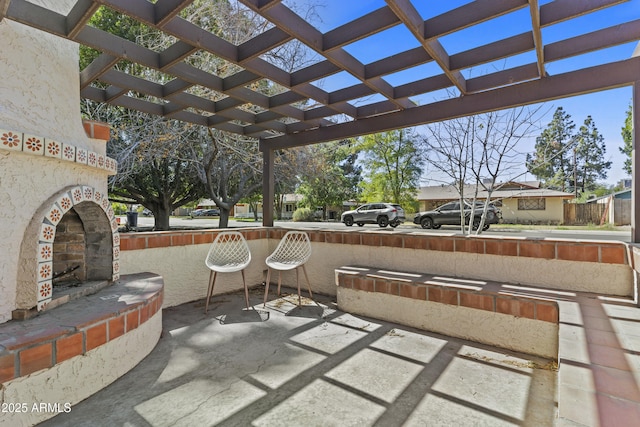 view of patio with an outdoor brick fireplace and a pergola