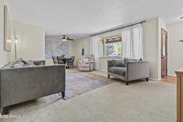 living area featuring carpet floors, a textured ceiling, and baseboards