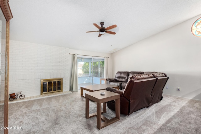 living room with a textured ceiling, light colored carpet, ceiling fan, and a fireplace