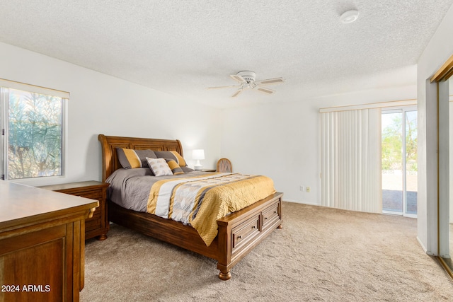 carpeted bedroom featuring a textured ceiling, access to exterior, and ceiling fan