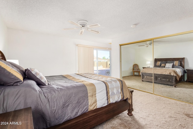 bedroom featuring a closet, a textured ceiling, light carpet, and ceiling fan