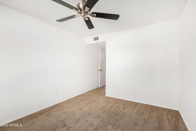 empty room featuring a textured ceiling, ceiling fan, and carpet floors