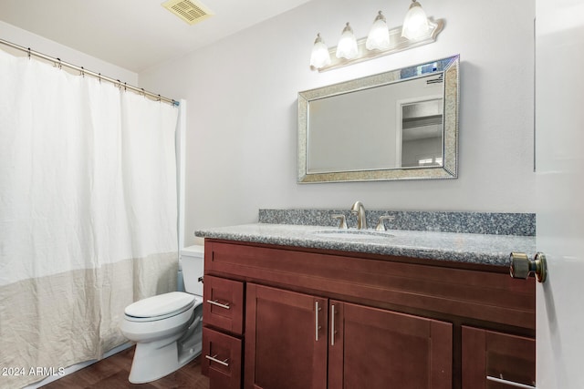 bathroom featuring wood-type flooring, vanity, and toilet