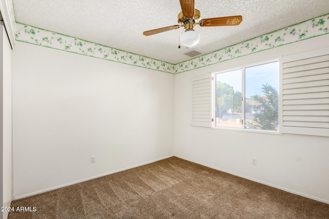 spare room with carpet, a textured ceiling, and ceiling fan