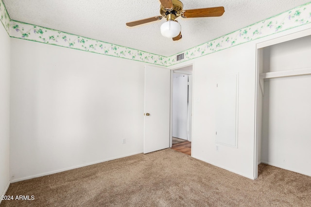 unfurnished bedroom featuring a closet, a textured ceiling, ceiling fan, and carpet floors