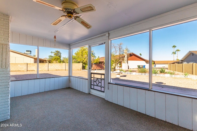 unfurnished sunroom featuring ceiling fan