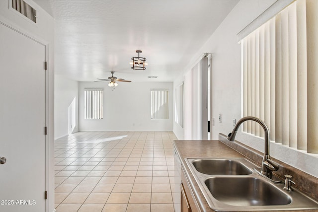 kitchen with sink, light tile patterned floors, and ceiling fan