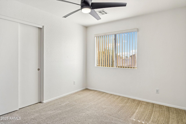 unfurnished bedroom featuring carpet, ceiling fan, and a closet