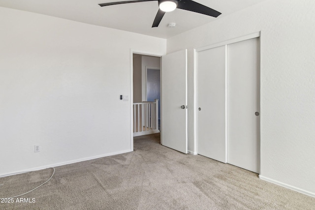 unfurnished bedroom featuring light colored carpet, a closet, and ceiling fan