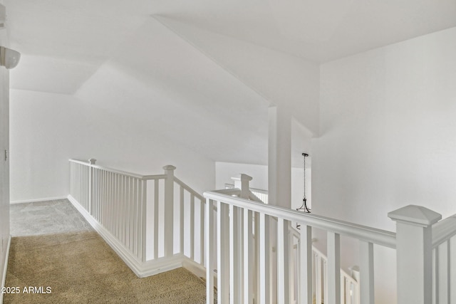 hallway featuring light colored carpet and lofted ceiling