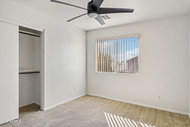 unfurnished bedroom with light colored carpet, a closet, and ceiling fan