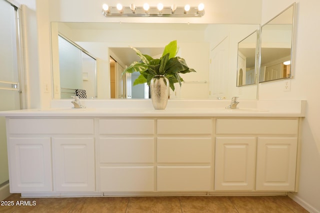 full bath with double vanity, tile patterned floors, and a sink