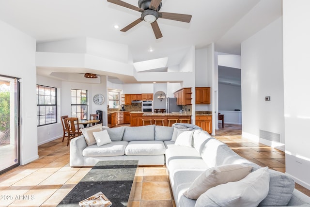 living room featuring high vaulted ceiling, light tile patterned flooring, and ceiling fan