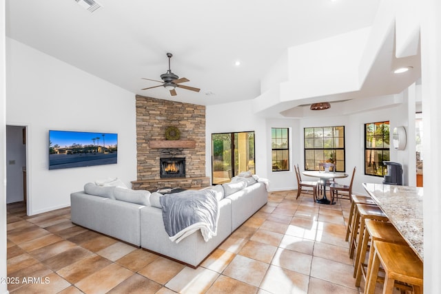 tiled living room with a fireplace, high vaulted ceiling, and ceiling fan