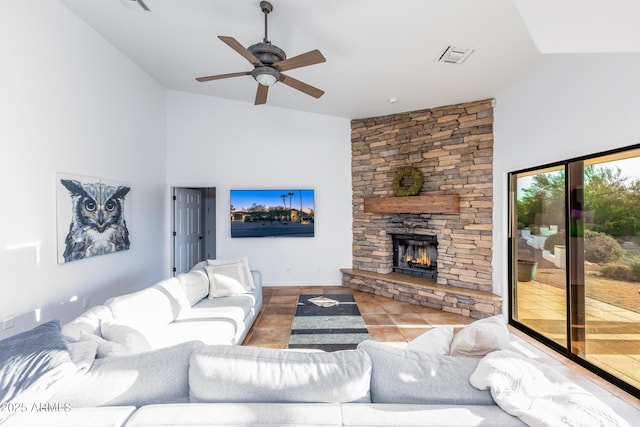 tiled living room featuring ceiling fan, a stone fireplace, and lofted ceiling