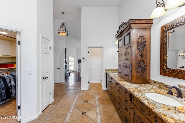 bathroom with toilet, tile patterned flooring, a high ceiling, and vanity