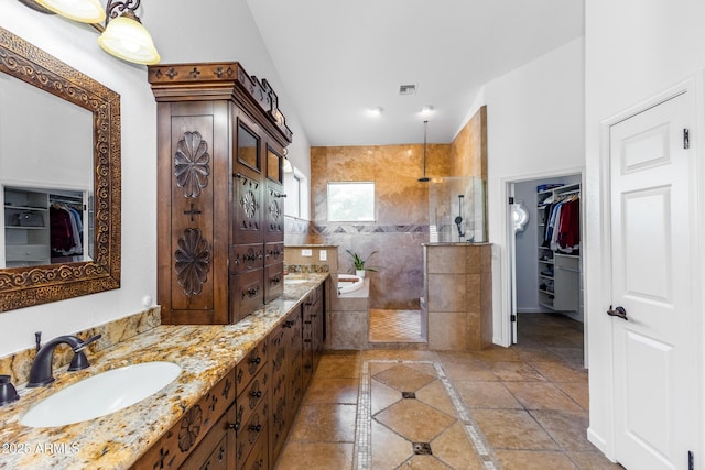 bathroom featuring a tile shower and vanity