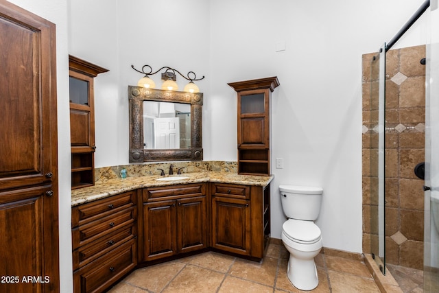 bathroom featuring toilet, a shower with shower door, and vanity