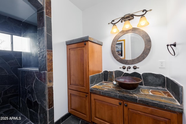 bathroom with tiled shower and vanity