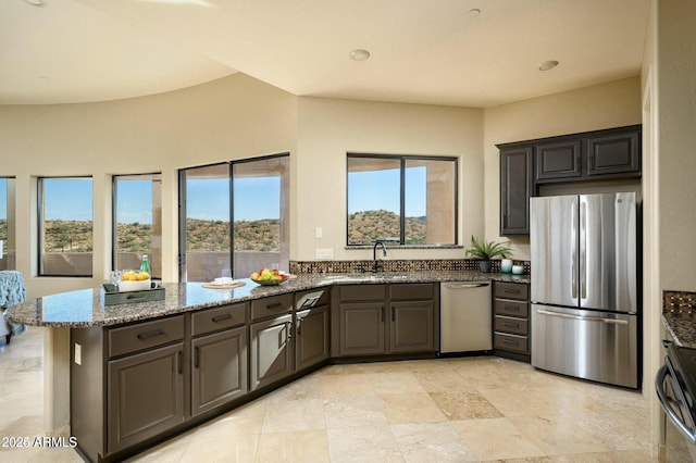 16569 E Trevino Dr, Fountain Hills, AZ 85268 - kitchen with stainless steel appliances, a peninsula, stone countertops, healthy amount of natural light, and recessed lighting