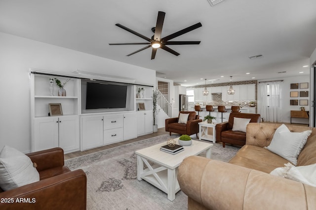 living room featuring light hardwood / wood-style flooring and ceiling fan