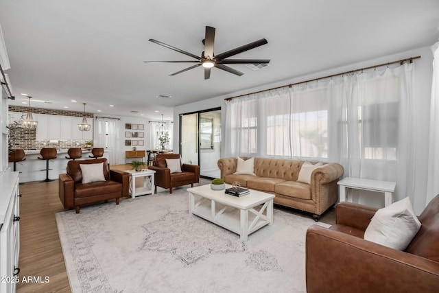 living room with ceiling fan and light wood-type flooring