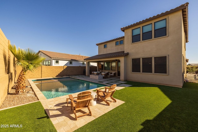 rear view of house with a fenced in pool, a patio, a lawn, and outdoor lounge area