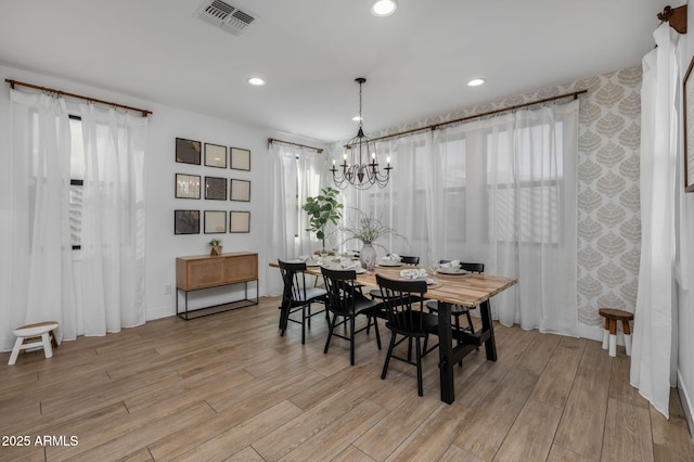 dining area featuring light hardwood / wood-style floors and a notable chandelier