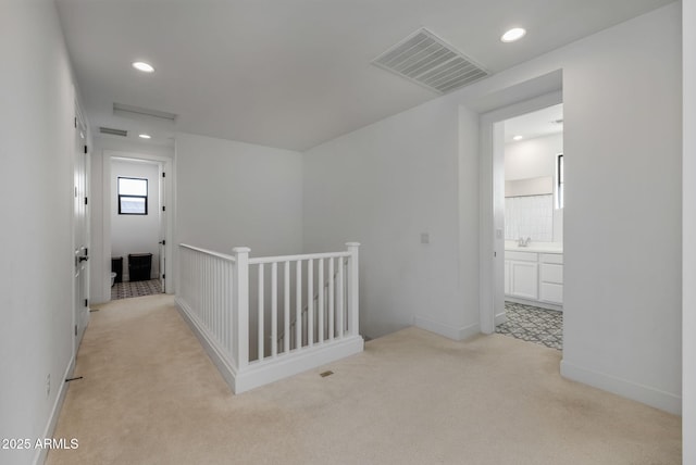 hallway with sink and light carpet