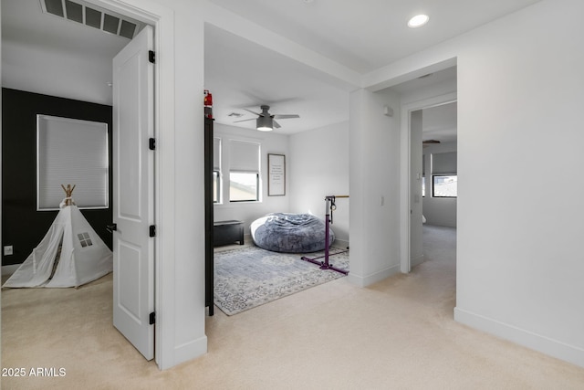 hallway with light colored carpet and a healthy amount of sunlight