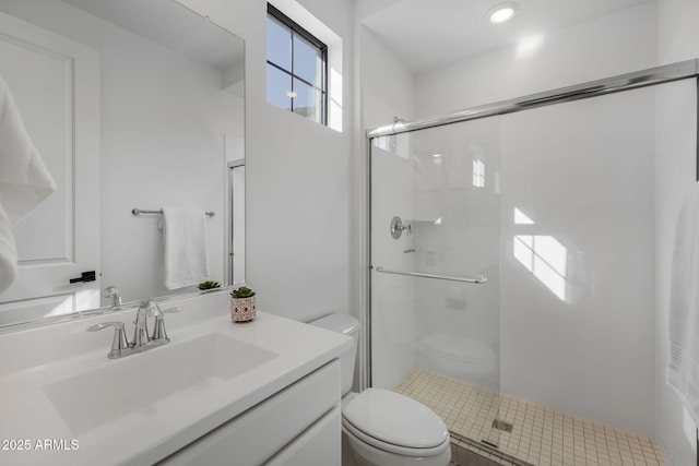 bathroom with toilet, a shower with door, and vanity