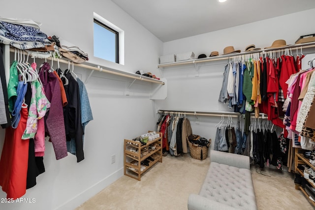 walk in closet featuring light colored carpet