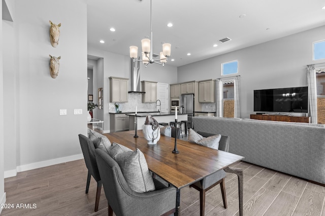 dining room featuring wood-type flooring, an inviting chandelier, and sink