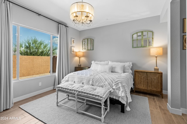 bedroom with an inviting chandelier and light hardwood / wood-style floors