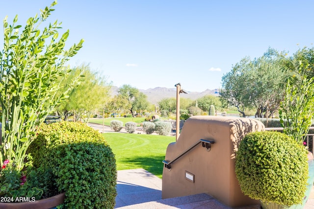 surrounding community with a mountain view and a lawn