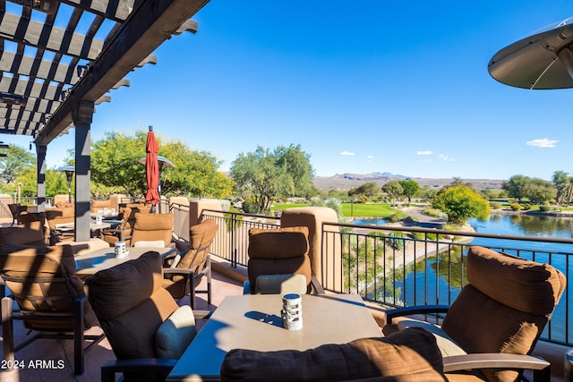 view of patio / terrace with a balcony, a water and mountain view, and a pergola