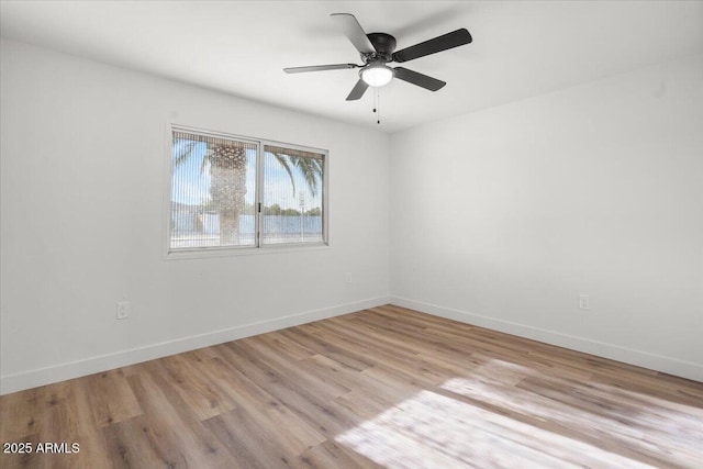 empty room featuring light wood-style flooring, baseboards, and a ceiling fan