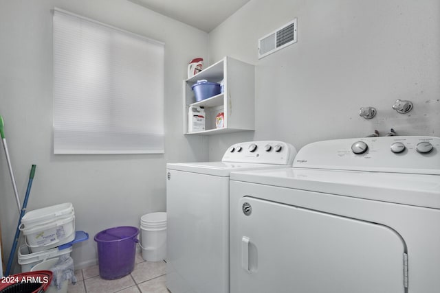 laundry area with washer and clothes dryer and light tile flooring