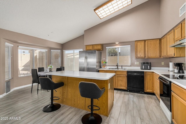 kitchen featuring electric range oven, dishwasher, freestanding refrigerator, under cabinet range hood, and a sink