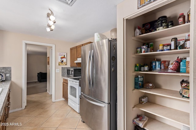 kitchen with stainless steel appliances and light tile patterned flooring