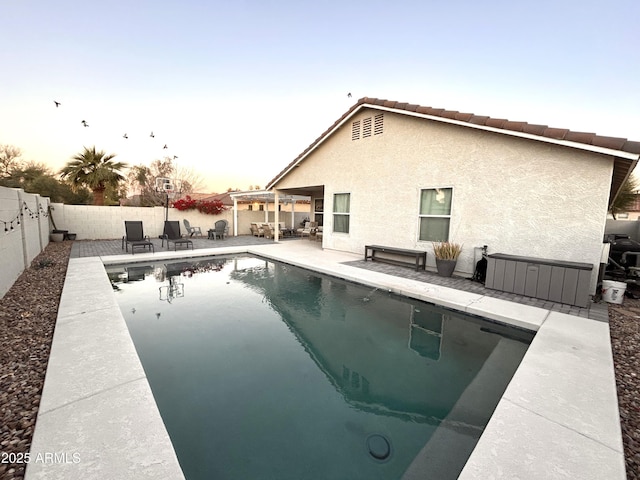 pool at dusk featuring a pergola and a patio